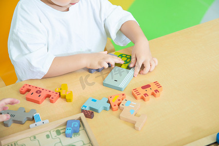儿童益智玩具白天小孩的手室内桌面玩拼图积木摄影图配图