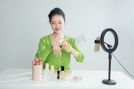 美妆主播直播化妆在手上喷补水化妆品摄影图配图