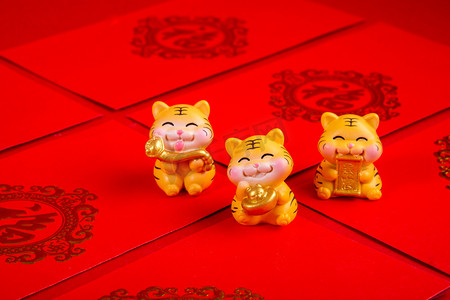 红包摄影照片_春节三只老虎摆件红包摆放摄影图配图