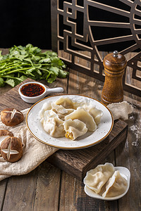 立冬冬至木板上白色陶瓷碗里的饺子摄影图配图