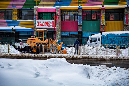 东北大雪摄影照片_东北冬日一辆铲车街道铲雪摄影图配图
