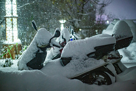 东北初雪电动车街道被雪覆盖摄影图配图