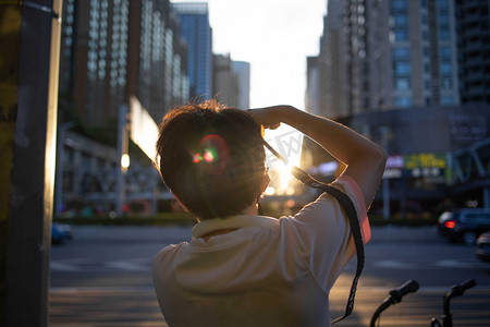 广州日落拍夕阳的摄影师背影摄影图配图