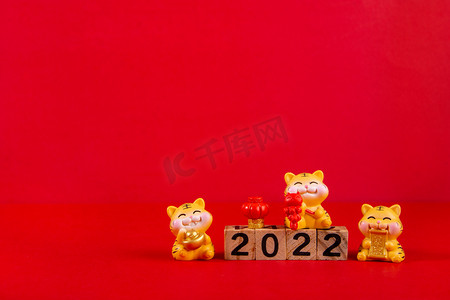春节白天三个卡通老虎红色背景摆放摄影图配图
