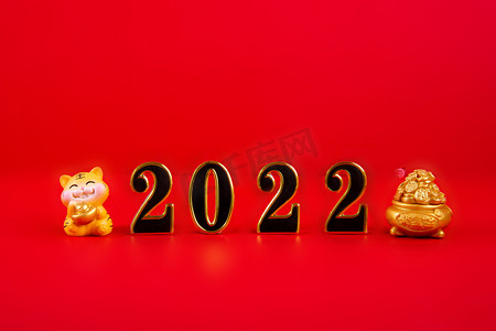 红色背景元旦喜庆摄影照片_春节新年2022老虎摆件红色背景摆放摄影图配图