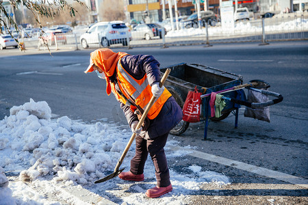 东北大雪摄影照片_冬天白天除雪的环卫工人户外马路除雪摄影图配图