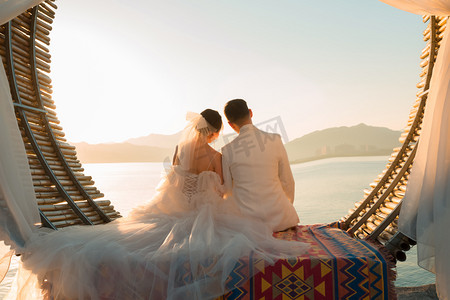 婚纱照素材照片夕阳两个人户外依靠摄影图配图