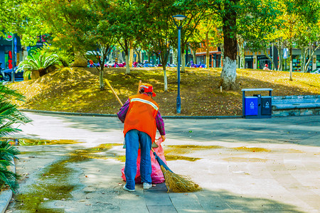 全屋保洁摄影照片_城市环卫工工作照片下午一个人公园扫地摄影图配图