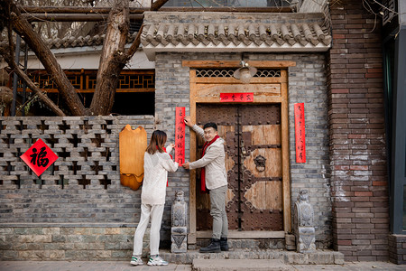 飞船贴图摄影照片_春节人像贴春联春节过年虎年春节摄影图配图