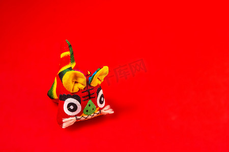 春节白天布老虎玩偶红色背景摆放摄影图配图