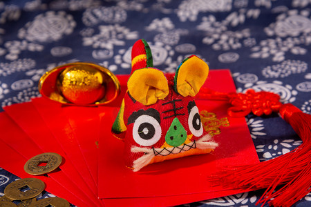 新年红包摄影照片_春节新年布老虎玩偶红包摆放摄影图配图
