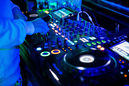 dj摄影照片_夜生活晚上灯光下的DJ台酒吧调整按钮摄影图配图