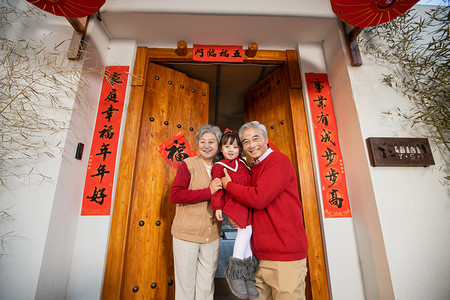 春节爷爷奶奶抱着孙女在门口开心的笑摄影图配图