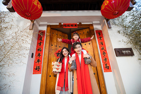 春节回家在大门口开心的笑的一家三口摄影图配图