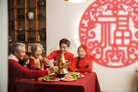 全家福实景摄影照片_年夜饭一家人温馨的在一起吃火锅摄影图配图