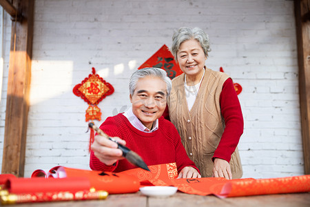 春节除夕爷爷奶奶写对联摄影图配图