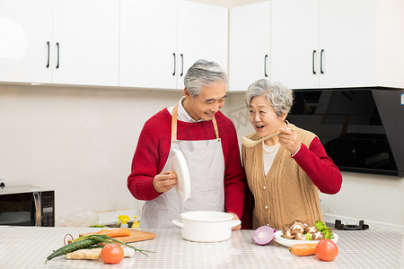 幸福的老年夫妻在厨房里煲汤品尝摄影图配图