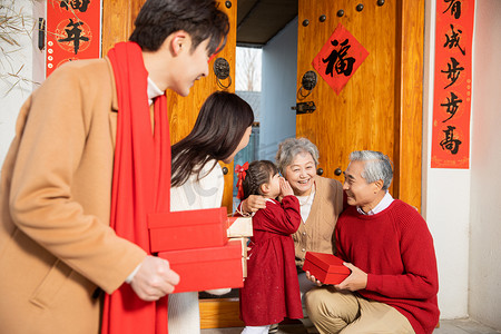 春节一家人回家孙女在奶奶耳边说悄悄话摄影图配图