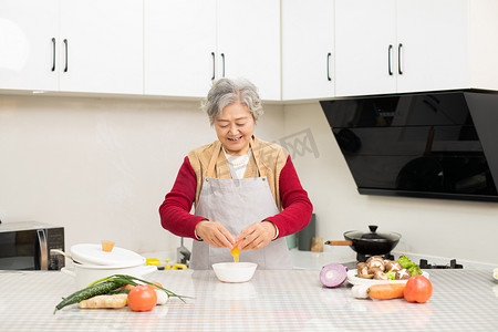 老奶奶在厨房为一家人准备晚餐摄影图配图