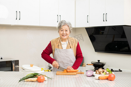 老年新年摄影照片_奶奶居家厨房做饭摄影图配图