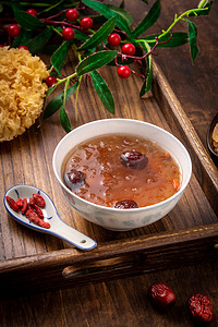 银耳粥摄影照片_餐饮美食白天红枣银耳莲子羹木桌摆放摄影图配图