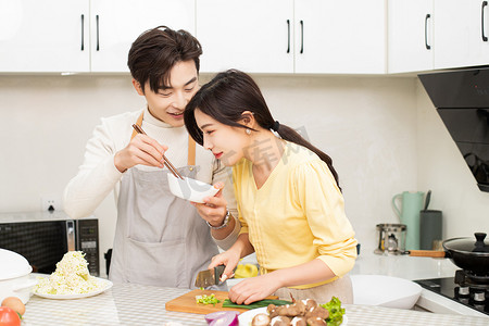婚恋家庭白天年轻夫妇厨房做饭时候互动摄影图配图