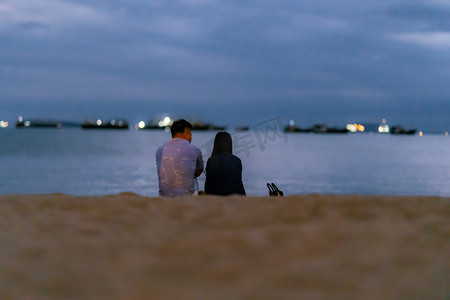 海边情侣摄影照片_傍晚情侣海边吹海风摄影图配图