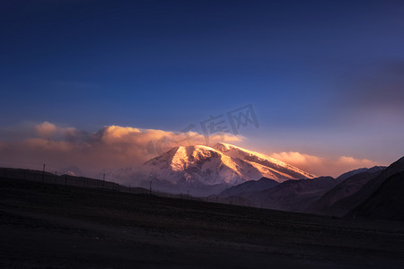 日照摄影照片_新疆克州慕士塔格峰雪山日照金山摄影图配图