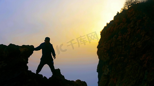 呐喊摄影照片_男人登山攀登山峰悬崖意境人物剪影