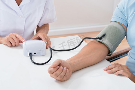 生病摄影照片_医生检查病人的血压