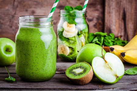 猕猴桃背景摄影照片_在玻璃罐里的绿色健康的果汁︰ 香蕉、 猕猴桃、 菠菜、 青苹果 