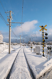 本地火车与洁白的雪花落在日本的铁路轨道