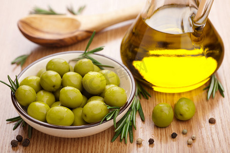 烹饪文化摄影照片_绿色橄榄和石油