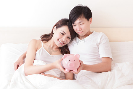 幸福的情侣与粉红猪存钱罐