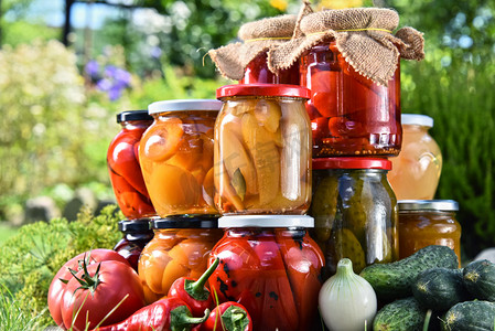 怪物里尔摄影照片_罐子里的腌渍的蔬菜和水果在花园里