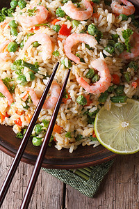 筷子与虾和蔬菜炒的米饭。垂直