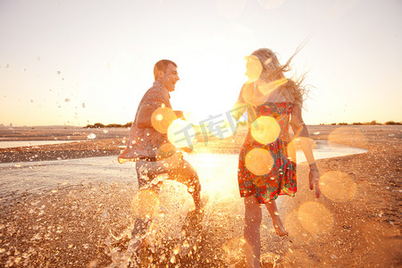 阳光奔跑摄影照片_在海滩上奔跑的情侣