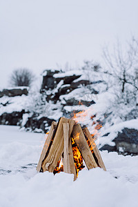 翻开魔法书摄影照片_营地火灾在冬季的时间, 周围是雪的背景下的冰湖。概念冒险活动假期户外徒步运动 