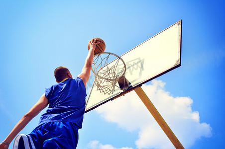 篮球赛封面摄影照片_行动飞得很高和得分的篮球运动员