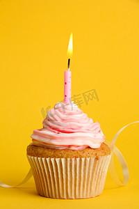 美味的生日蛋糕的蜡烛，在黄色背景上