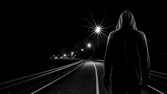 人走摄影照片_十几岁男孩独自在街上站在晚上