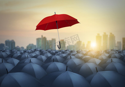 商务红色背景摄影照片_独特的红伞中与城市背景下的黑色遮阳伞