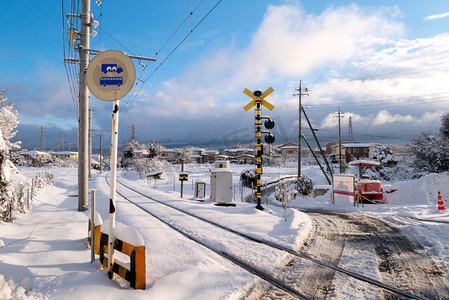 日本旅游易拉宝摄影照片_与白色的雪落在寒冬季节，日本当地火车的铁路轨道