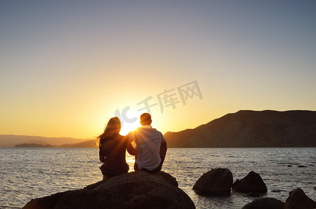 海滩情侣摄影照片_看着太阳的恩爱夫妻