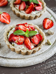 草莓馅饼与香草奶油在轻质朴的木板上。甜甜的夏季甜点