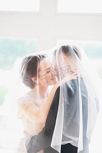 情侣白色摄影照片_.美丽的新娘和新郎肖像用在脸上的面纱。时尚爱婚礼情侣接吻和拥抱