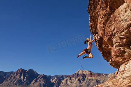 信心摄影照片_坚持这种悬崖的摇滚女登山者.