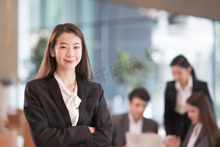 亚洲成功的女商人的画像，背景的同事.