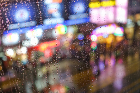 伦敦眼摄影照片_情感抽象背景与焦的灯景在弥敦道 Hong 本港背后雨滴眼液在窗玻璃-专注于由于浅景深的几滴