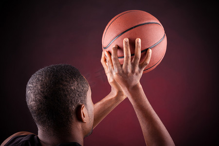篮球运动员摄影照片_黑人背景下的年轻男性篮球运动员